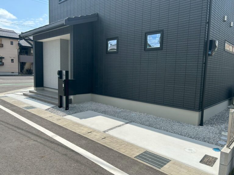 黒い外壁に調和するシンプルな駐車スペース